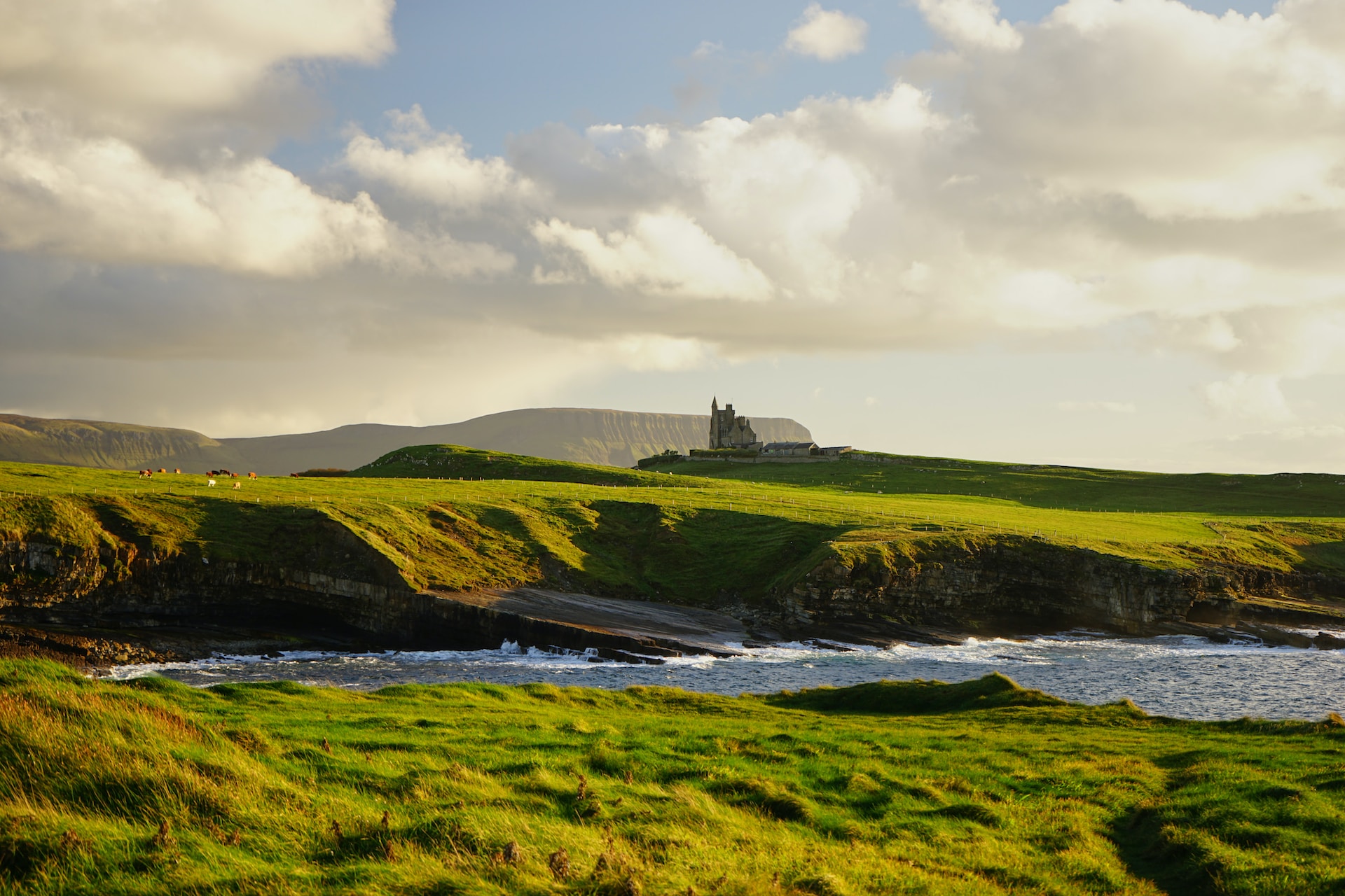 Green hills beside the ocean and a castle on the hill
